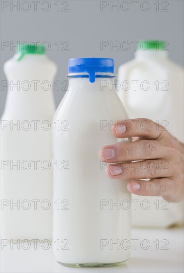 Man reaching for milk bottle.