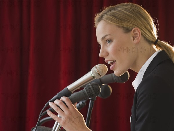 Businesswoman speaking into microphone.