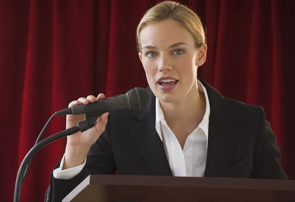 Businesswoman speaking into microphone.