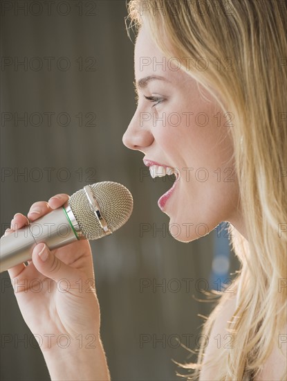 Woman singing into microphone.