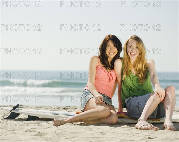 Multi-ethnic women sitting on surf board. Date : 2008