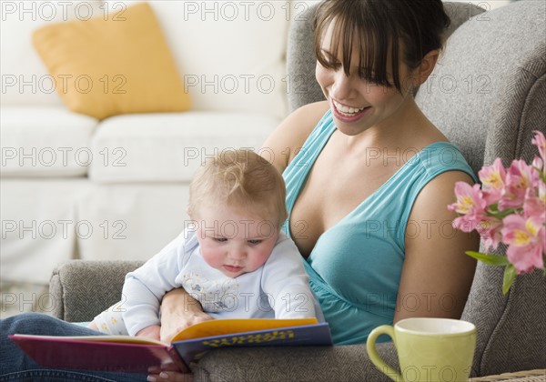 Mother and baby looking at book. Date : 2008