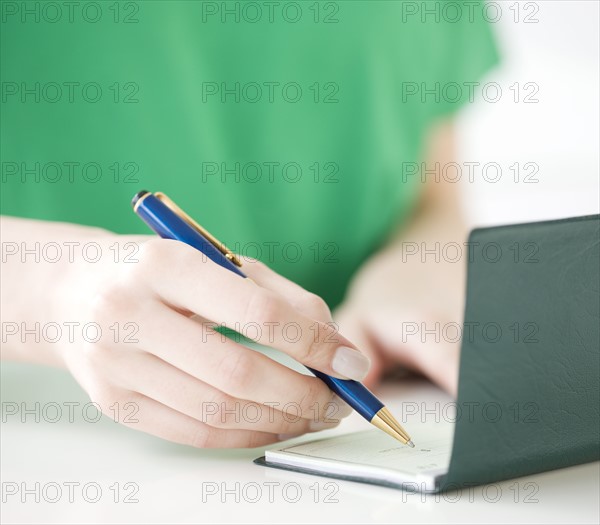 Close up of woman writing check. Date : 2008