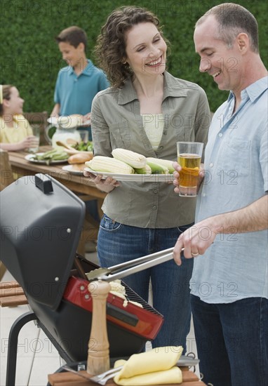 Family with two children barbecuing.