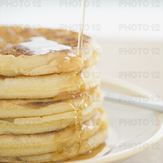 Close up of syrup pouring on waffles. Date : 2008