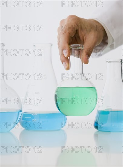 Male scientist holding beaker of liquid.