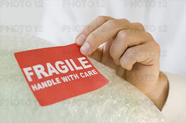 Man affixing fragile sticker.