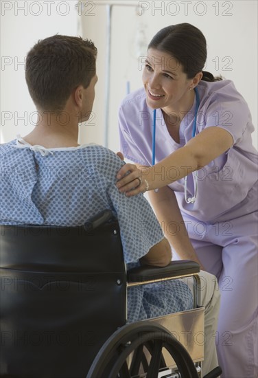 Female nurse with hand on patient’s shoulder.