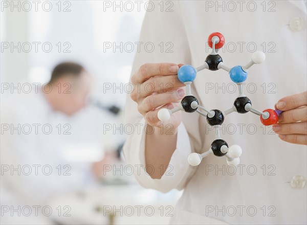 Female scientist holding molecular model.