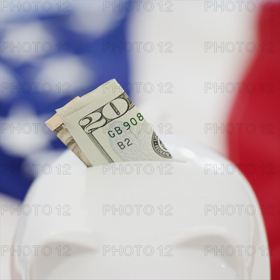 Twenty dollar bill in piggy bank slot. Date : 2008