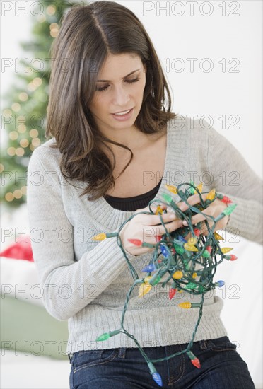 Woman untangling Christmas lights. Date : 2008