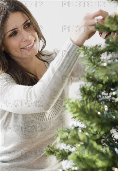 Woman decorating Christmas tree. Date : 2008