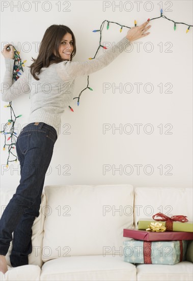 Woman hanging Christmas lights. Date : 2008