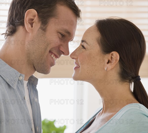 Hispanic couple smiling at each other.