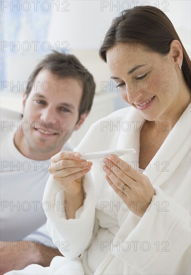 Hispanic couple looking at pregnancy test.