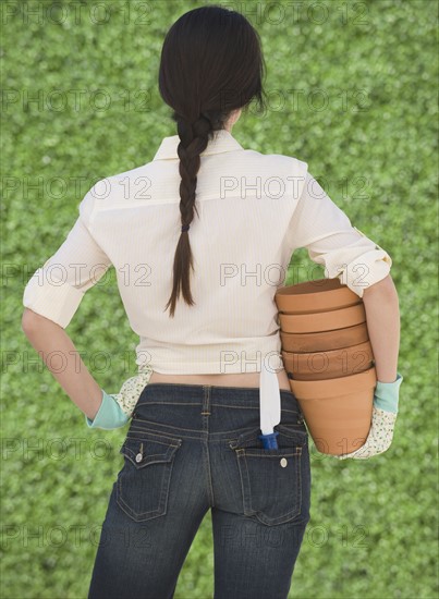 Woman holding terra cotta pots.