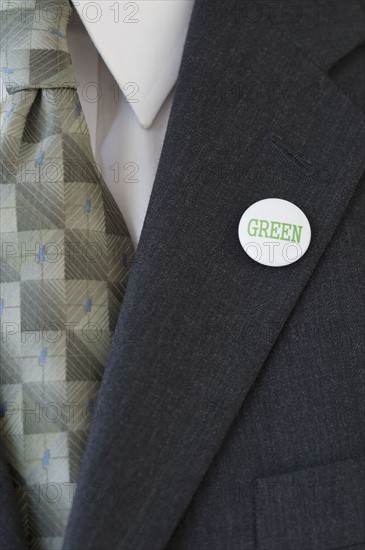 Eco-friendly button on businessman’s lapel.