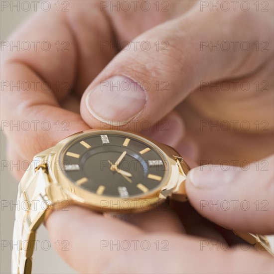 Close up of man winding watch.