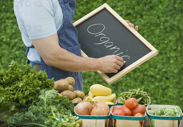 Farmer next to organic vegetables.