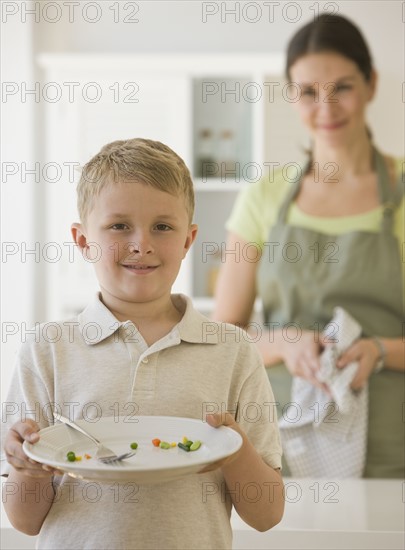 Boy holding dinner plate.