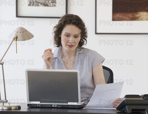 Businesswoman looking at laptop.