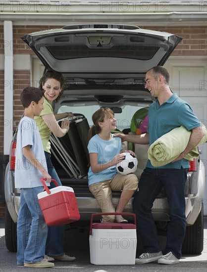 Family packing car for vacation.