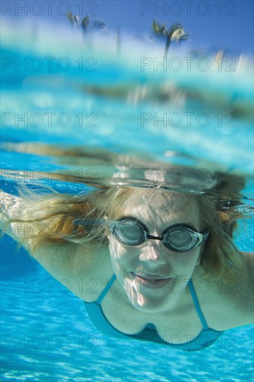 Woman wearing goggles underwater. Date : 2008