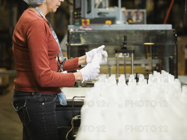 Hispanic female factory worker checking product. Date : 2008