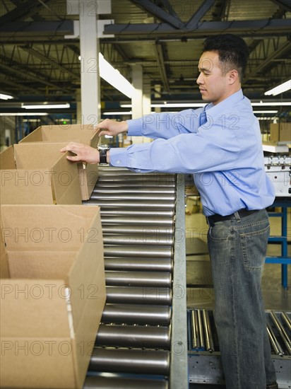Asian male factory worker checking product. Date : 2008