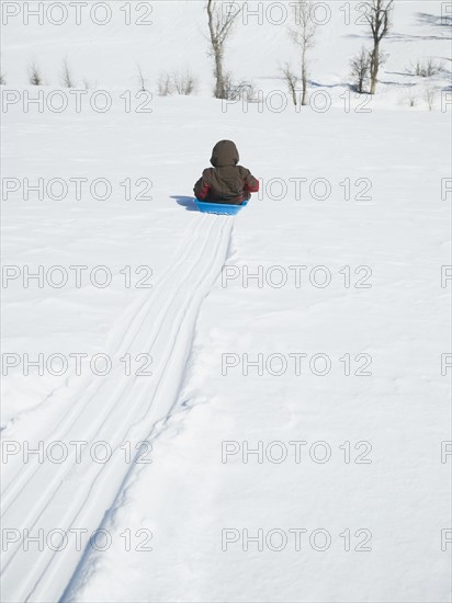 Boy riding on sled. Date : 2008