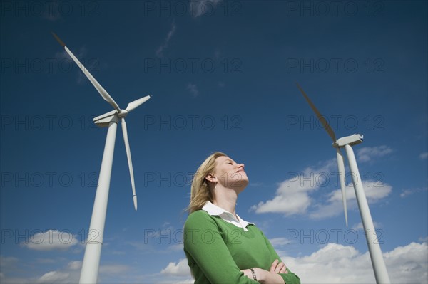 Low angle view of woman and wind turbines. Date : 2008