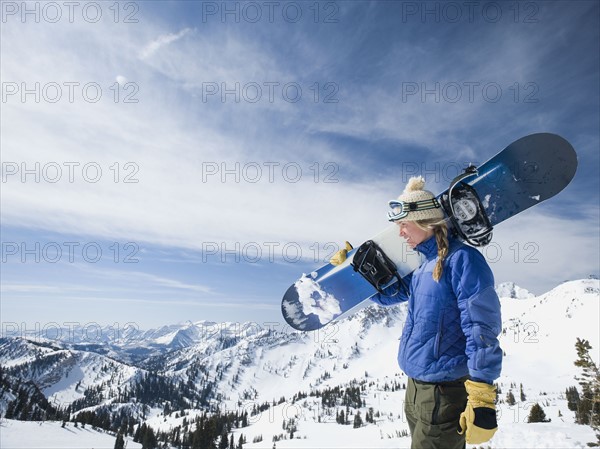 Woman holding snowboard, Wasatch Mountains, Utah, United States. Date : 2008