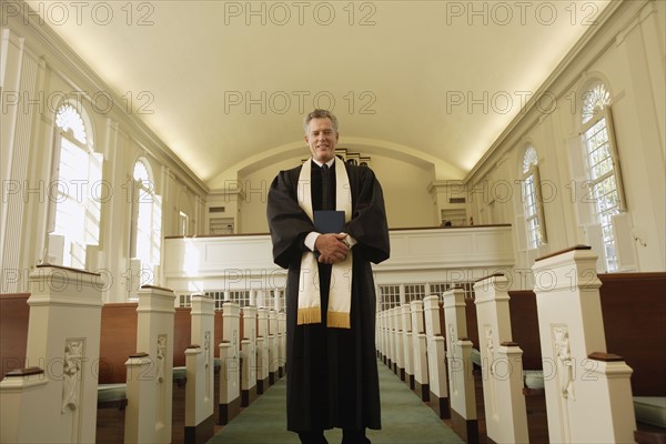 Priest holding bible in church. Date : 2008