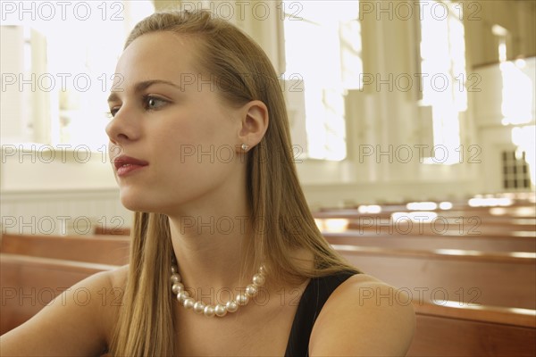 Woman wearing pearl necklace in church. Date : 2008