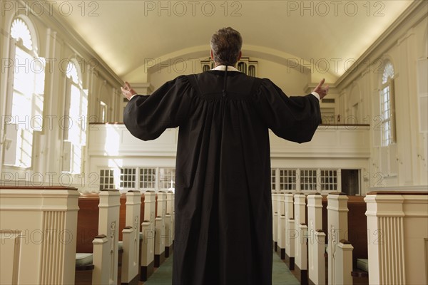 Priest with arms raised in church. Date : 2008