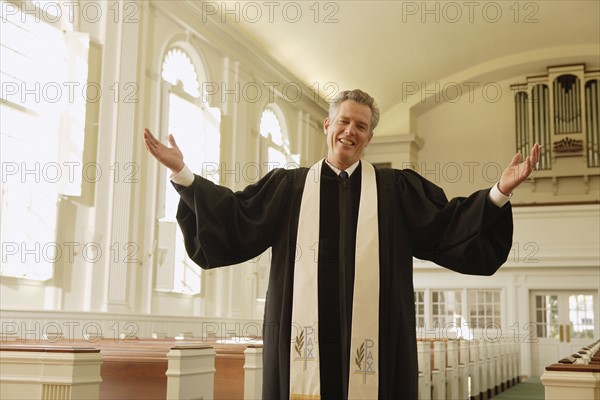 Priest with arms raised in church. Date : 2008