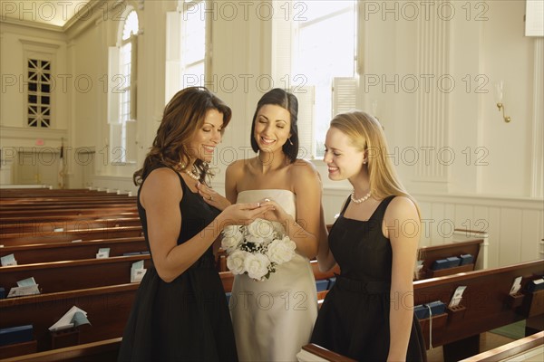 Bride showing ring to bridesmaids. Date : 2008