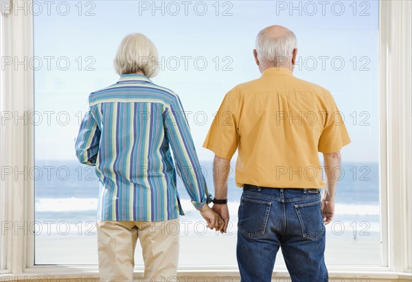 Senior couple looking out window. Date : 2008