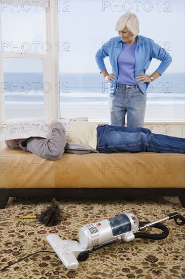 Woman looking at man sleeping next to vacuum. Date : 2008