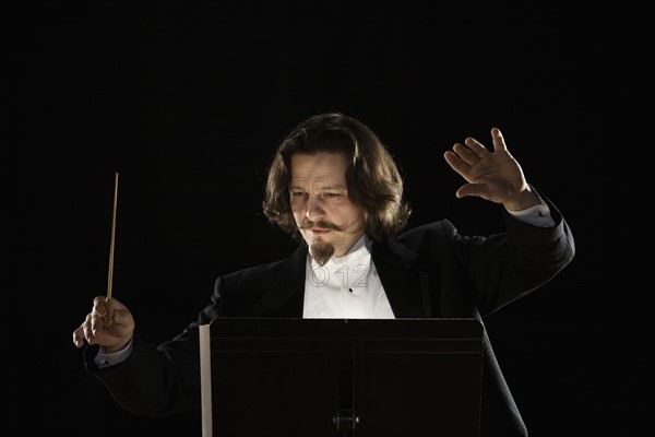 Man conducting behind music stand. Date : 2008