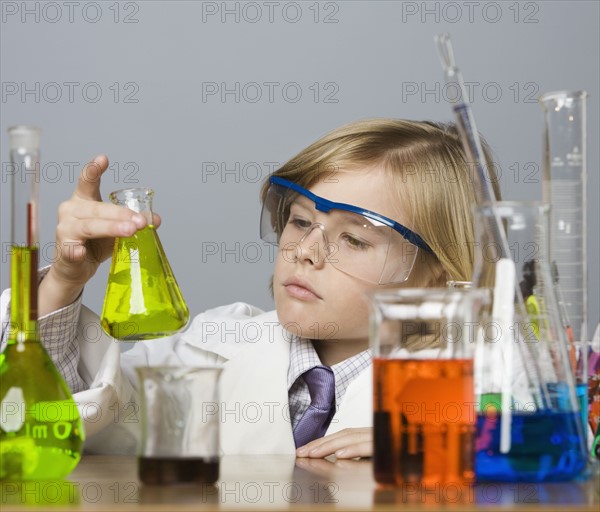 Boy looking at beaker of liquid. Date : 2008