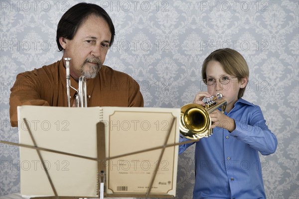 Boy playing trumpet for teacher. Date : 2008