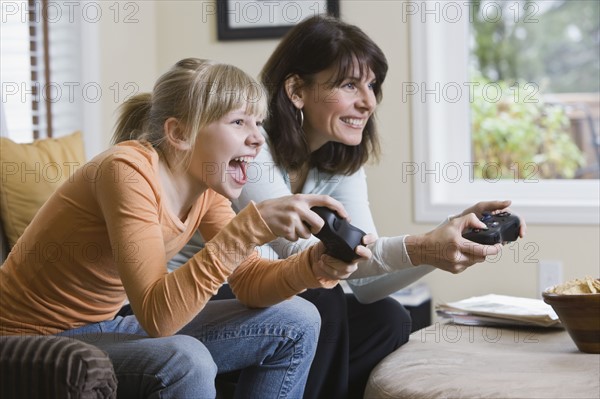 Mother and daughter playing video games. Date : 2008