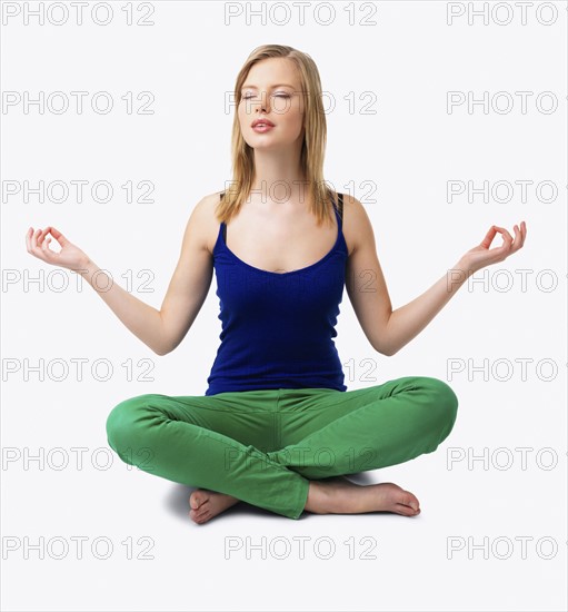 Studio shot of woman meditating. Date : 2008