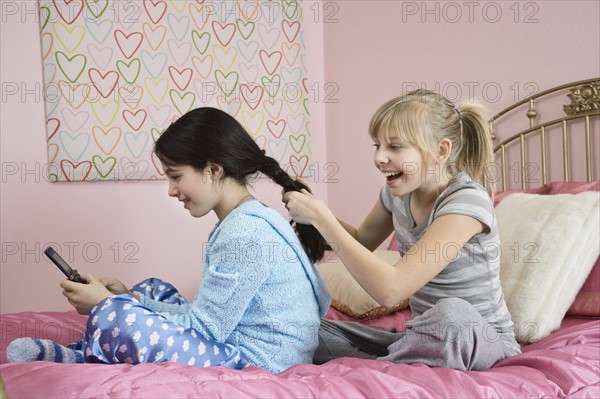 Girl braiding friend’s hair. Date : 2008