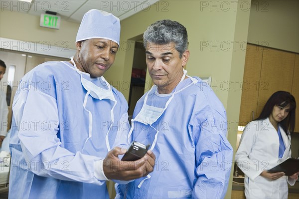 Multi-ethnic doctors looking at equipment. Date : 2008