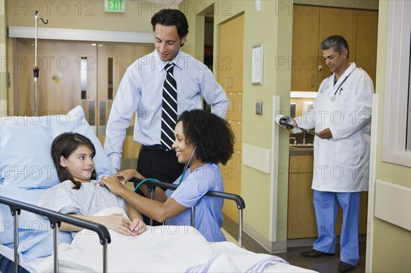 Girl in hospital gurney with father and nurse. Date : 2008