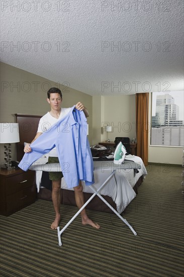 Businessman ironing shirt . Date : 2008