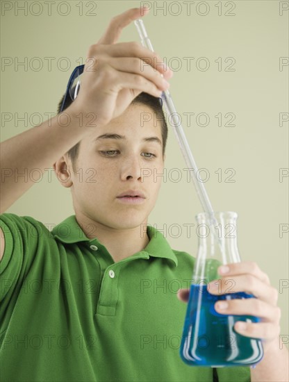 Boy measuring liquid in beaker. Date : 2008