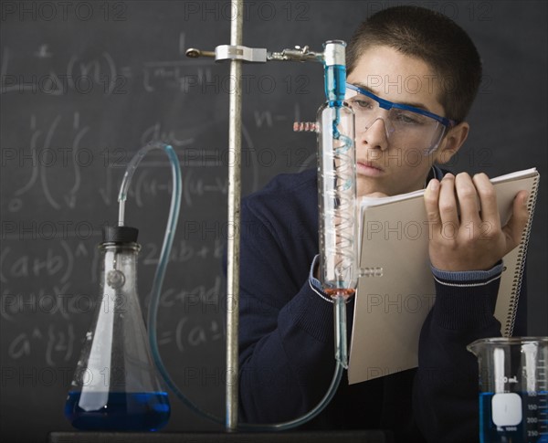 Boy taking notes in science class. Date : 2008